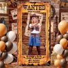 A woman dressed in western attire stands in a framed WANTED style prop with a reward sign.