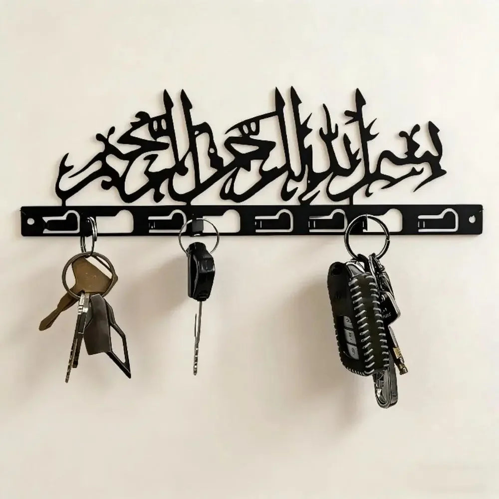 Black metal Islamic Arabic blessing key holder with hooks mounted on a white wall.