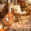 A fall porch goose dress and bow hair accessory displayed outdoors on a wooden deck.