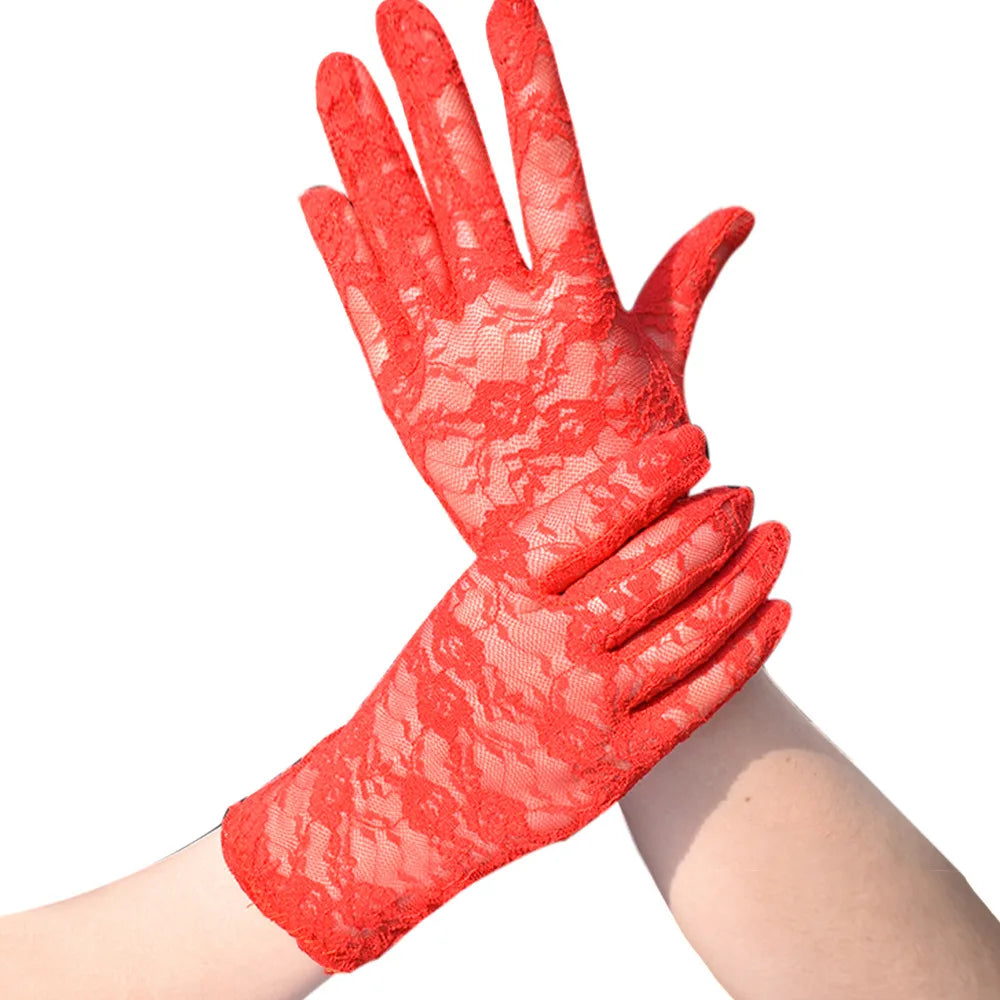 A close-up of bright red sheer lace gloves worn on a hand and wrist.