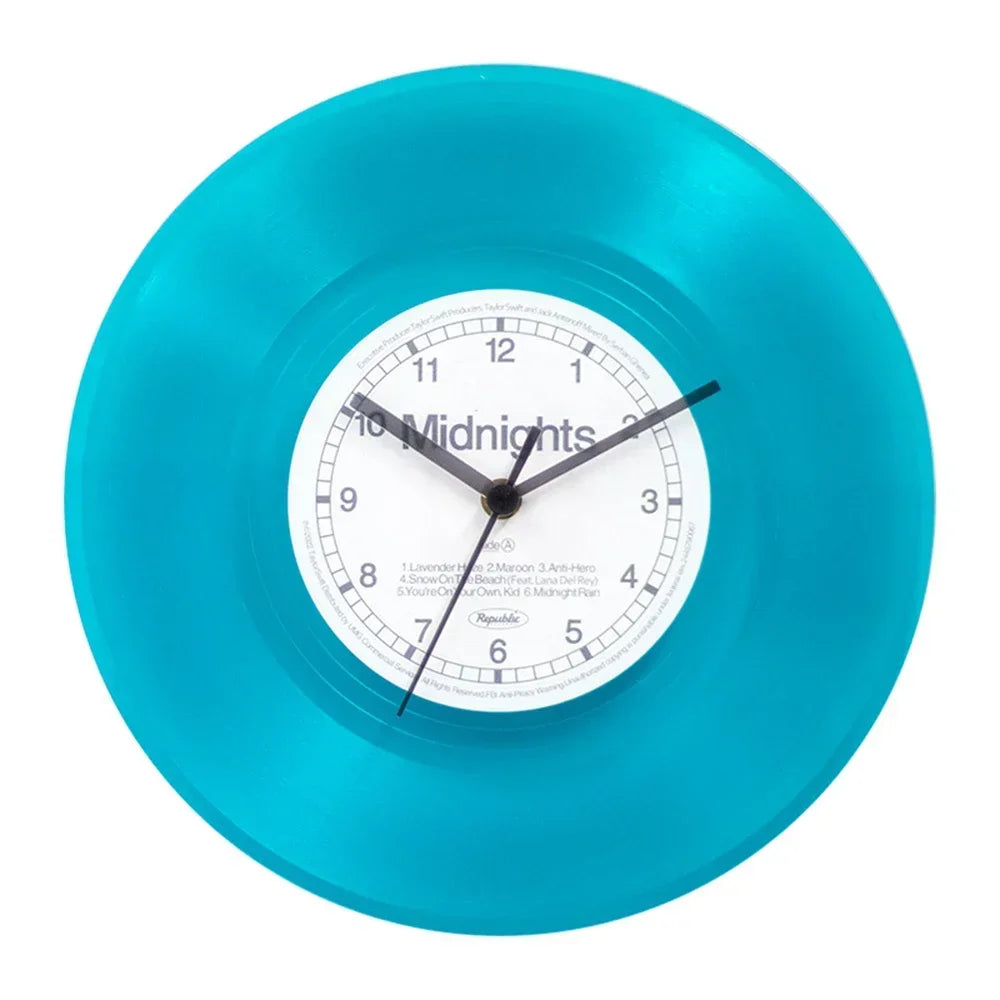 A bright turquoise vinyl record wall clock with a white face and black hands displaying midnight.