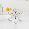 A minimalist molecular sculpture made of clear glass spheres on a white surface.