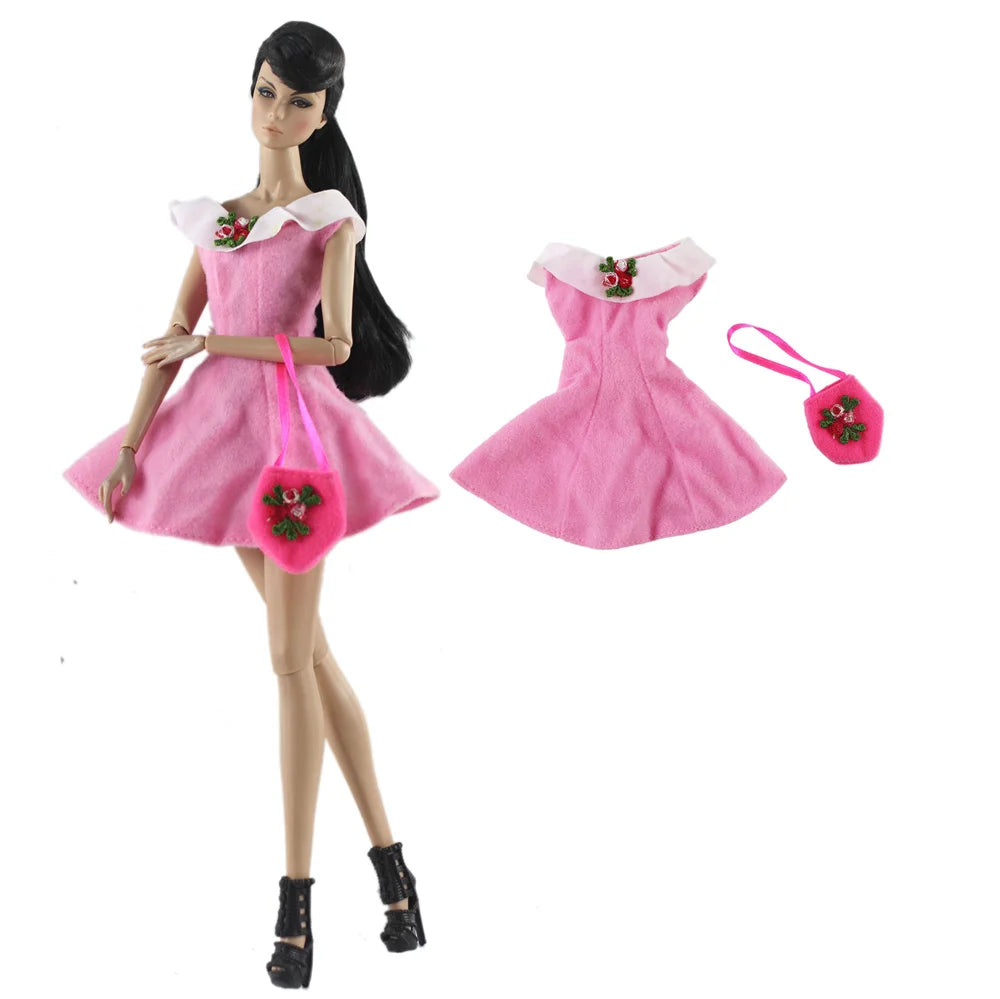 A pink handmade doll dress gown with floral accents displayed on a mannequin.