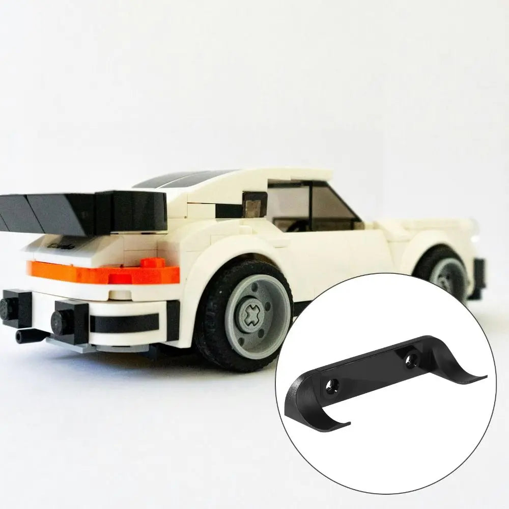 A white die-cast car model with a black wall mount display holder attached to the front bumper.