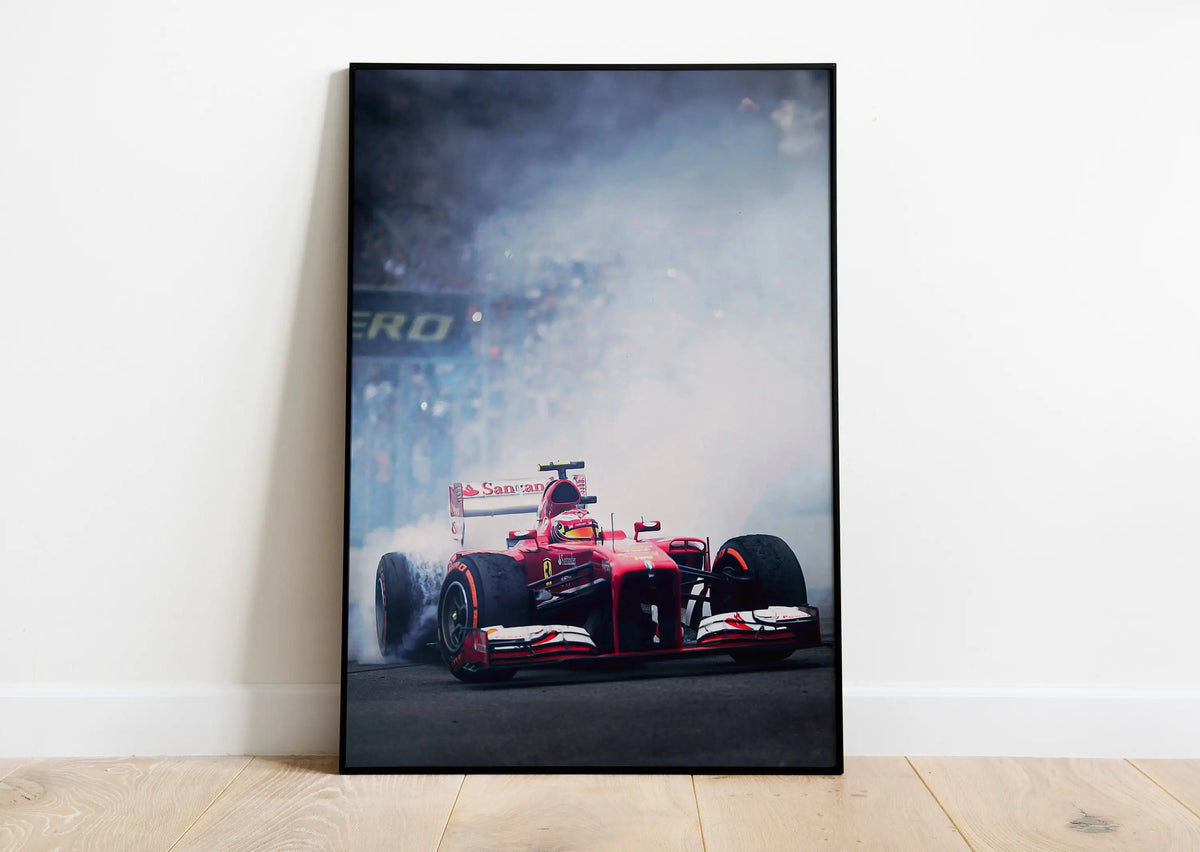 A black and white photograph of a red Formula 1 race car in a smoky environment.