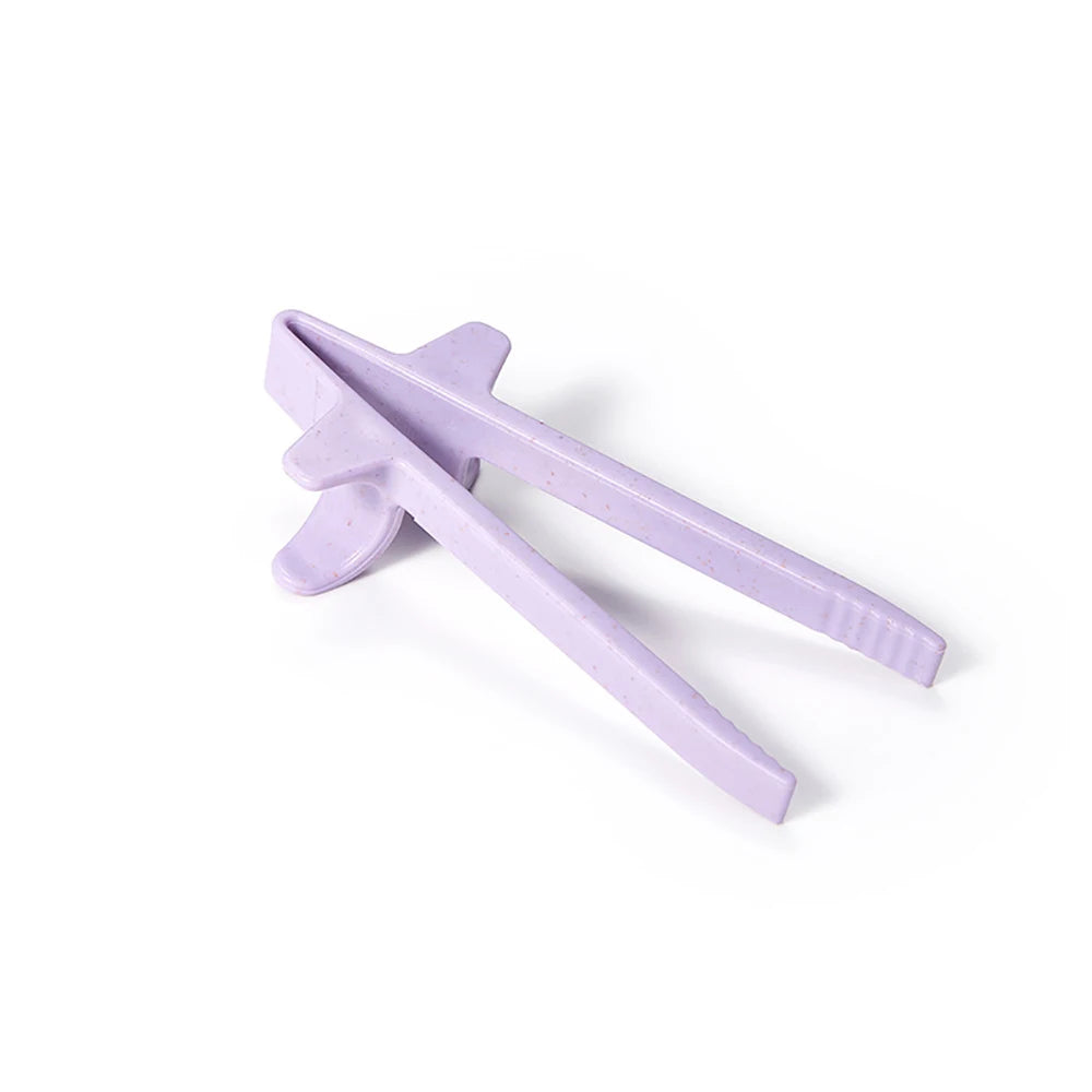 A pair of purple reusable wheat straw finger chopsticks shown against a white background.