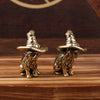 Une paire de statuettes de chats en laiton vintage portant des chapeaux à larges bords, posées sur une surface en bois.