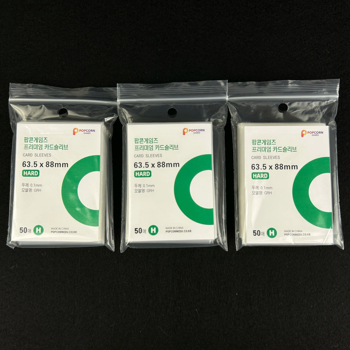 Three packages of clear protective card sleeves for Pokemon cards, labeled as 63.5 x 88mm hard plastic.