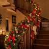 A festive Christmas garland with red bows and lights is displayed along a wooden staircase railing.