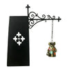 Black metal scrollwork lamp holder with a small brass figurine.