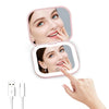 A hand holds a compact portable vanity mirror with dual magnification, showing a woman's face.