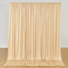 A floor-to-ceiling beige fabric backdrop curtain with vertical pleats.