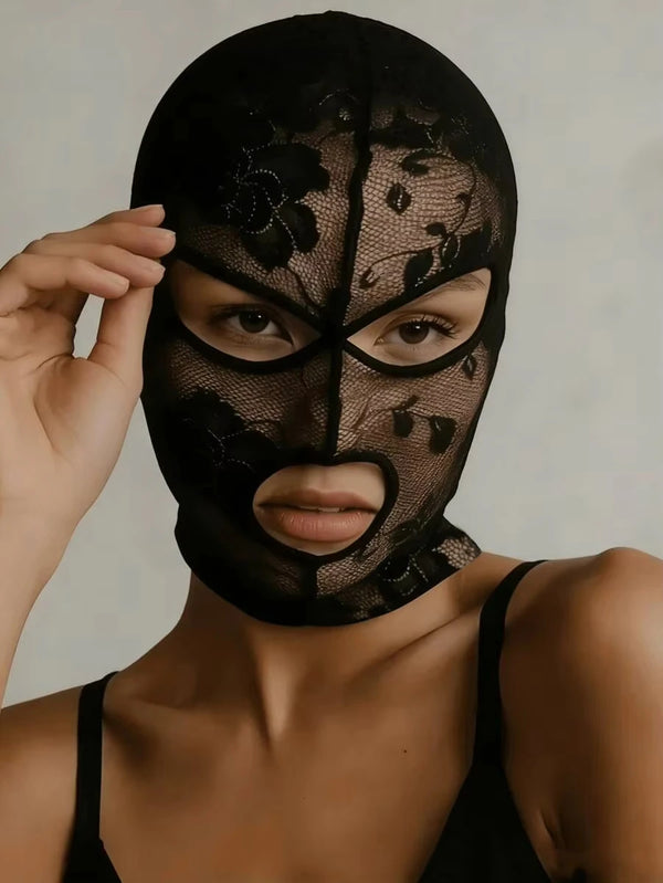 A model wearing a black Venetian Gothic lace mask with floral detailing.
