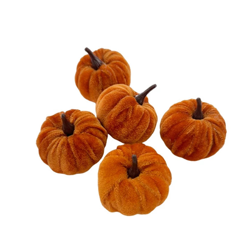A set of five small, orange, fuzzy foam pumpkins used for Halloween decoration.
