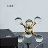 A minimalist molecular sculpture desk decor featuring gold-toned glass spheres on a dark surface.