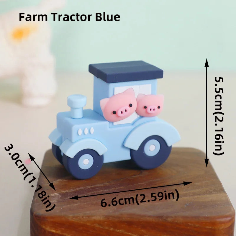 A blue farm tractor cake topper featuring pink pig figures on a wooden base.