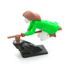 A small figurine of a witch and wizard riding a flying carriage, featuring green and brown elements.