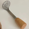 A manual wooden potato and pumpkin masher with a metal sieve end and a wooden handle.