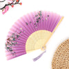 A vintage bamboo folding fan with purple fabric and pink floral accents, shown partially open.