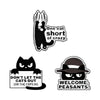 A set of cartoon cat enamel pins featuring a rude middle finger and daisy flower designs.