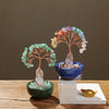 A natural crystal money tree with a rose quartz base featuring various colored crystals.