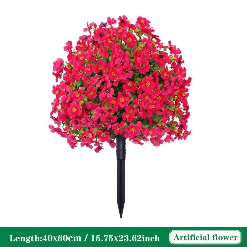 A dense bouquet of bright pink artificial petunias arranged on a black ground stake.