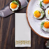 A plate of fried eggs served on a pink rimmed plate with rose gold trim and a white napkin.
