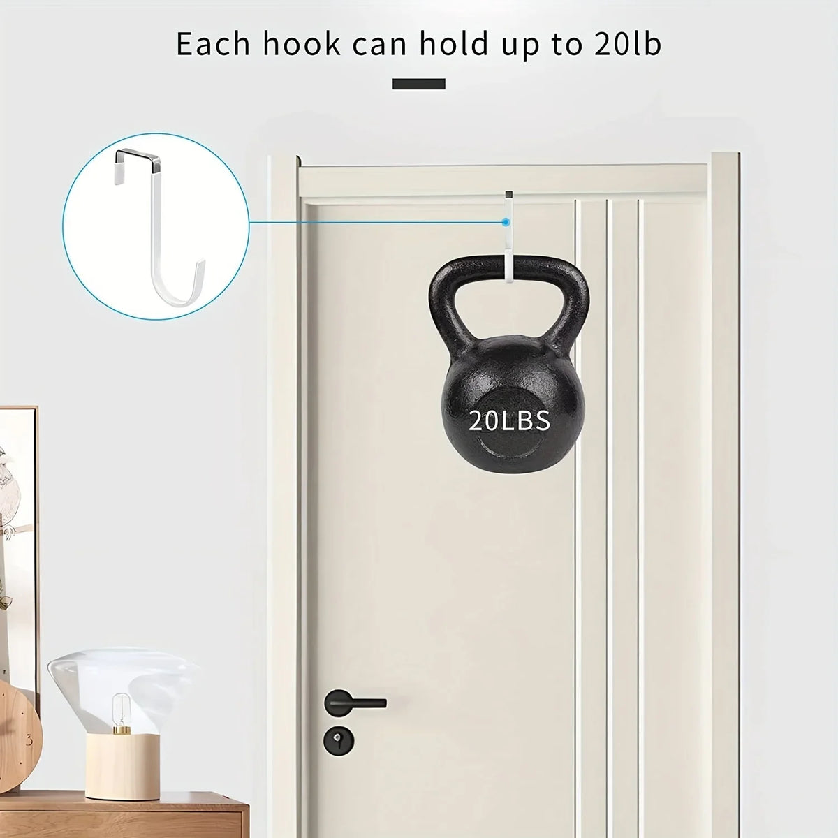 A black dumbbell shaped door hanger is shown hanging on a white door, demonstrating its 20lb capacity.