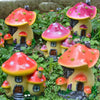 A collection of colorful resin mushroom house garden statues with pink and orange caps and yellow bodies.