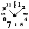 A black modern 3D acrylic wall clock showing the time, with DIY sticker numbers on the face.