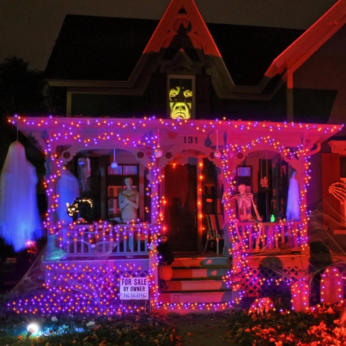 Halloween LED string lights in purple and orange decorate a house facade with glowing lights.