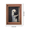 A framed print featuring a white ghost figure against a dark background.