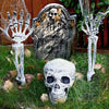 A set of realistic skeleton arm stakes used for Halloween lawn decor, including a skull and hand display.