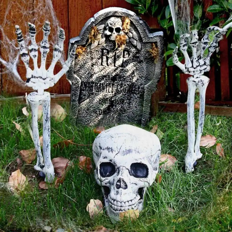 A set of realistic skeleton arm stakes used for Halloween lawn decor, including a skull and hand display.