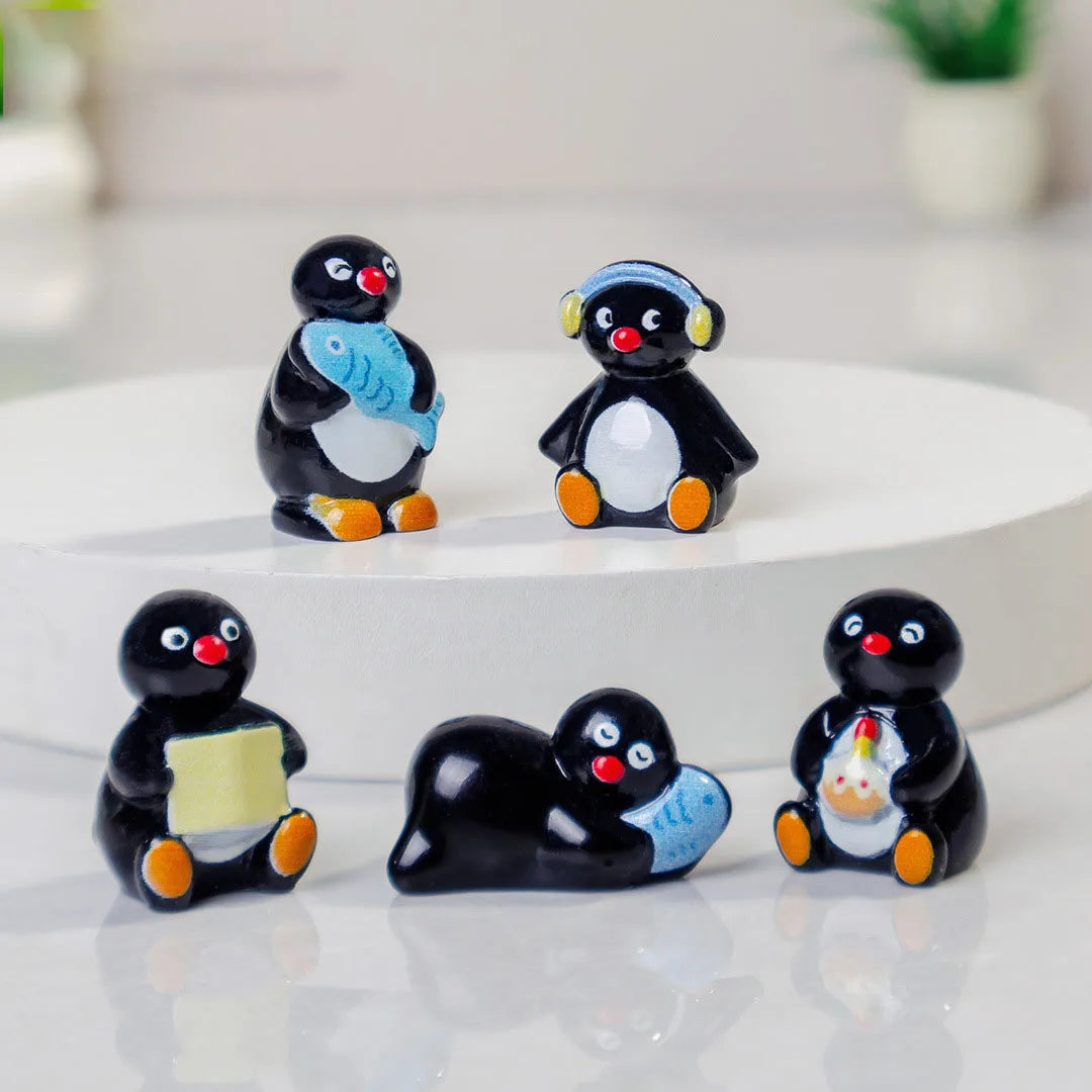 A set of cute cartoon penguin resin figurines in black and white with orange accents for fairy garden or Christmas decor.