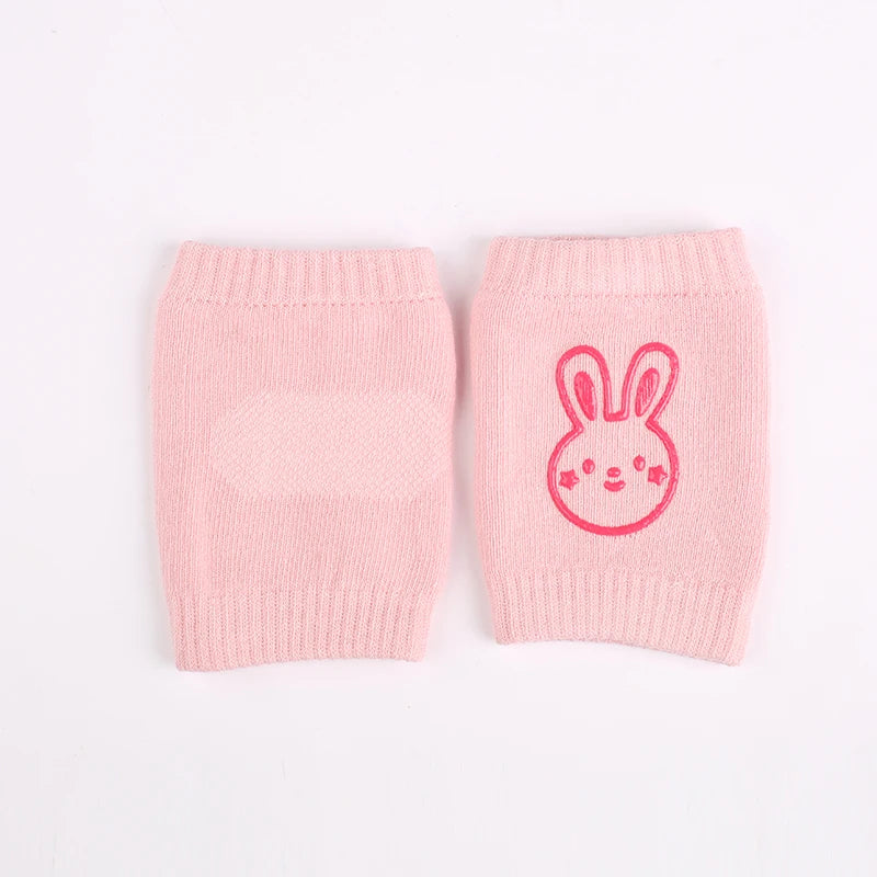 Pair of pink knitted knee pads with a rabbit face design for crawling infants