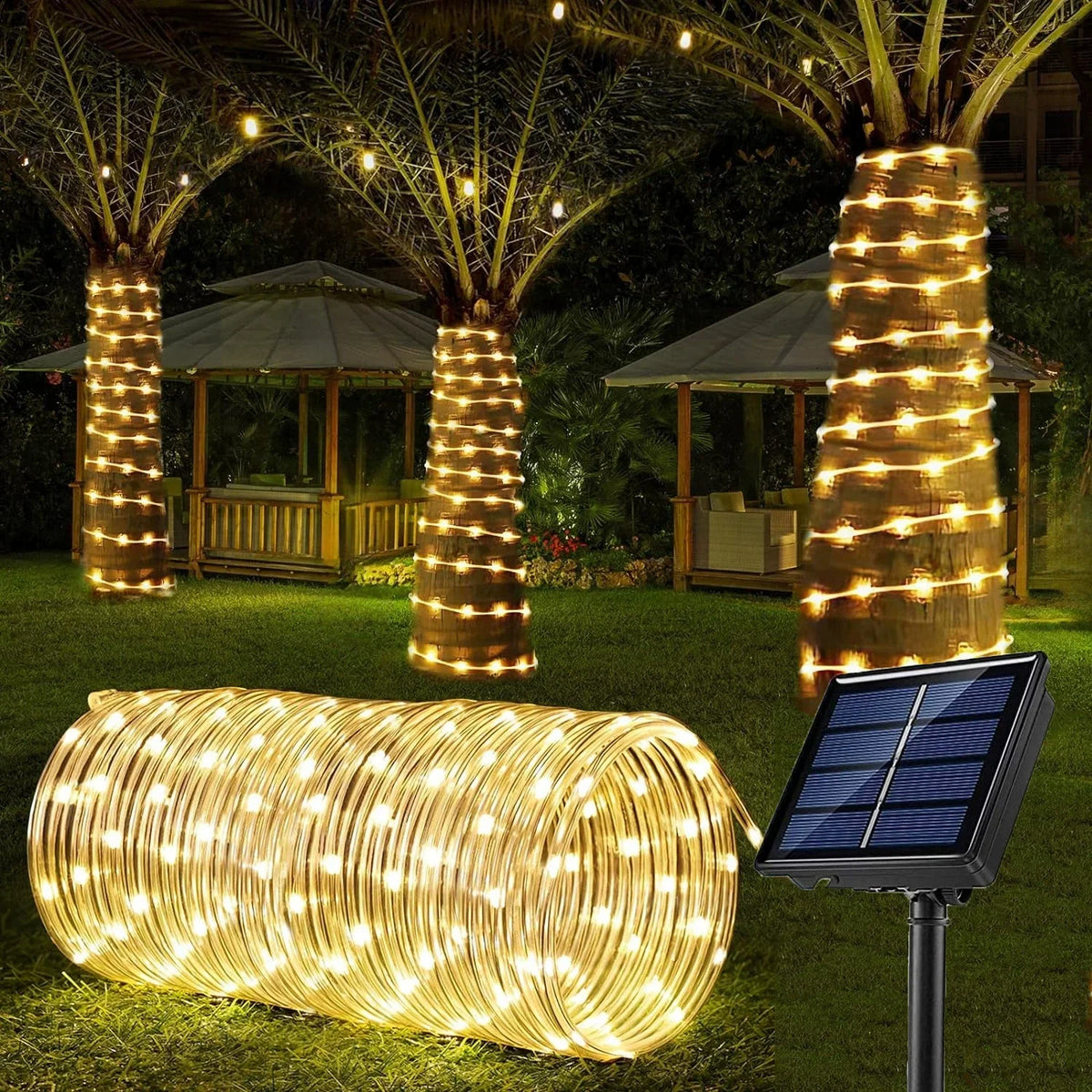 A long, cylindrical solar-powered LED rope light illuminates a grassy outdoor area with warm yellow lights.