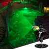 A Halloween laser projector emitting a bright green beam onto water in a dark outdoor setting.