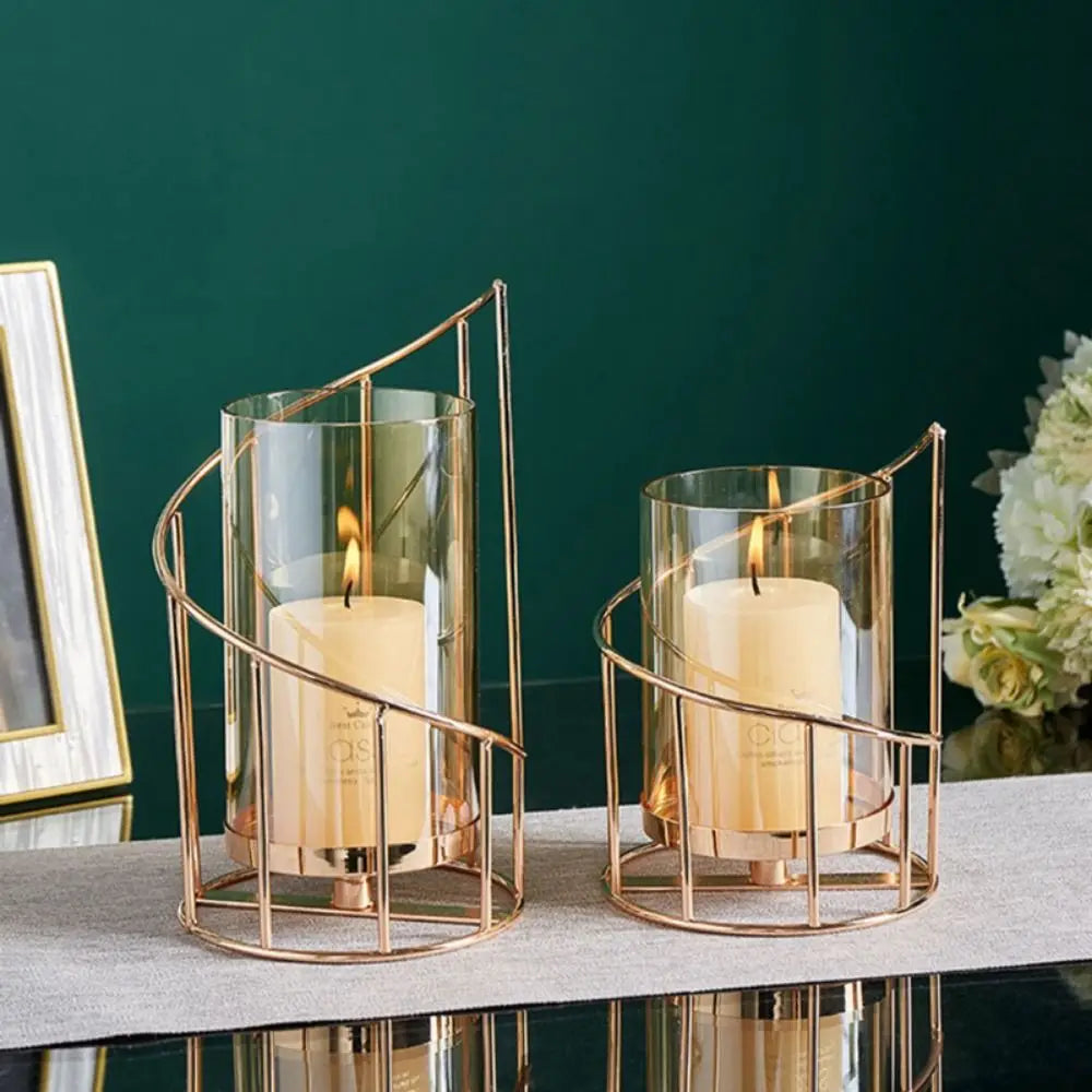 Elegant metal and glass candle holders with lit candles displayed on a dark surface.