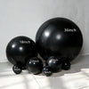 A collection of black latex balloons of various sizes, including 5 inch, 10 inch, 12 inch, 18 inch, and 36 inch.
