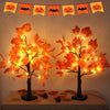 Lumières d'arbre de bouleau noir artificiel avec des feuilles orange lumineuses, présentées sur une table.