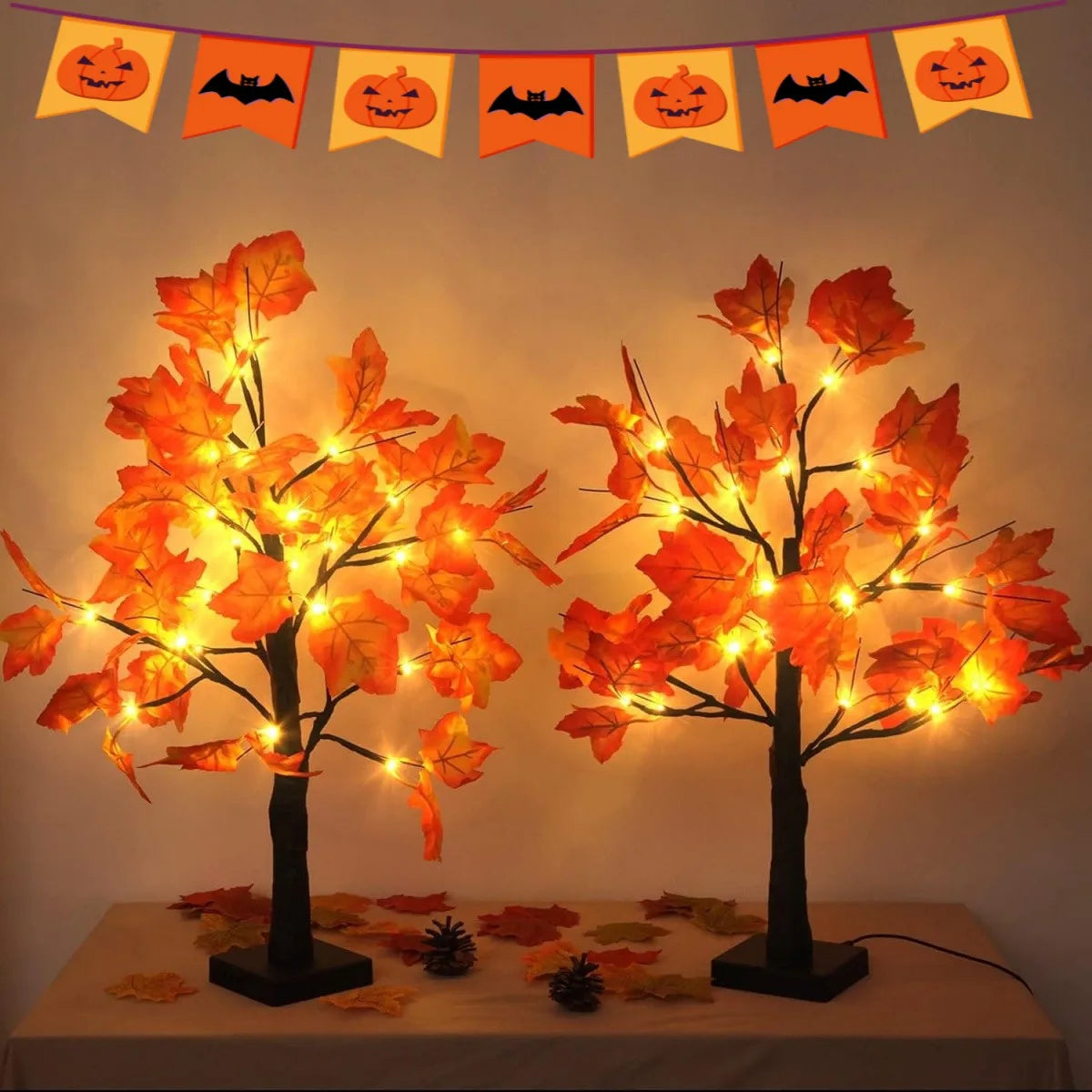 Lumières d'arbre de bouleau noir artificiel avec des feuilles orange lumineuses, présentées sur une table.