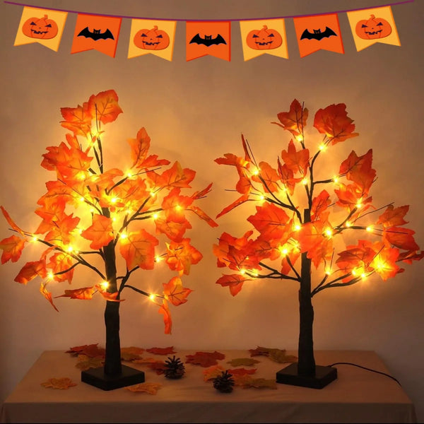 Artificial black birch tree lights with glowing orange leaves displayed on a table.