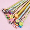 A collection of cartoon animal pencils with colorful eraser tops laid out on a pink background.