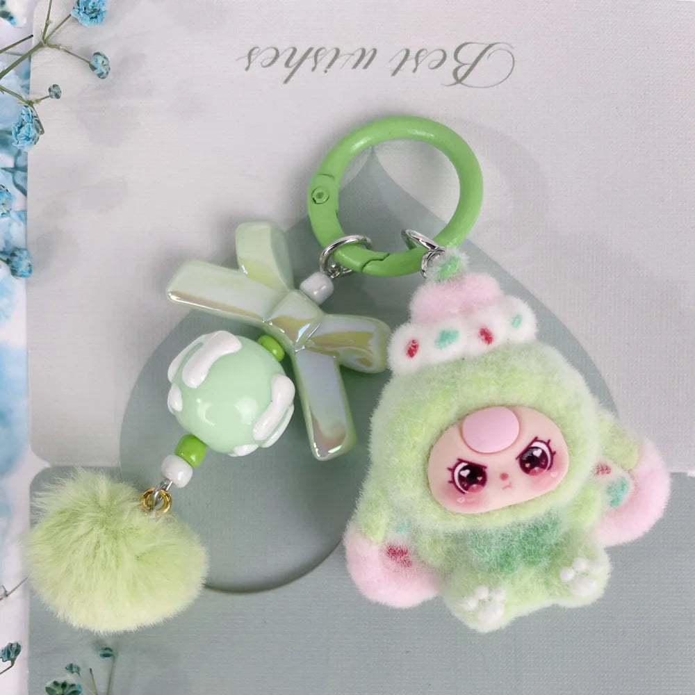A cute green heart plush keychain charm with pink accents and a green ring.
