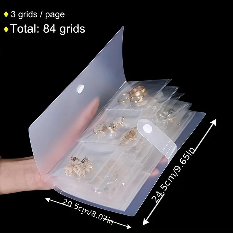A transparent jewelry organizer storage bag showing 84 grids of small gold-toned jewelry inside.
