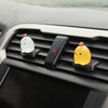 A black car interior display shows three luminous resin chicken ornaments: white, yellow, and orange.