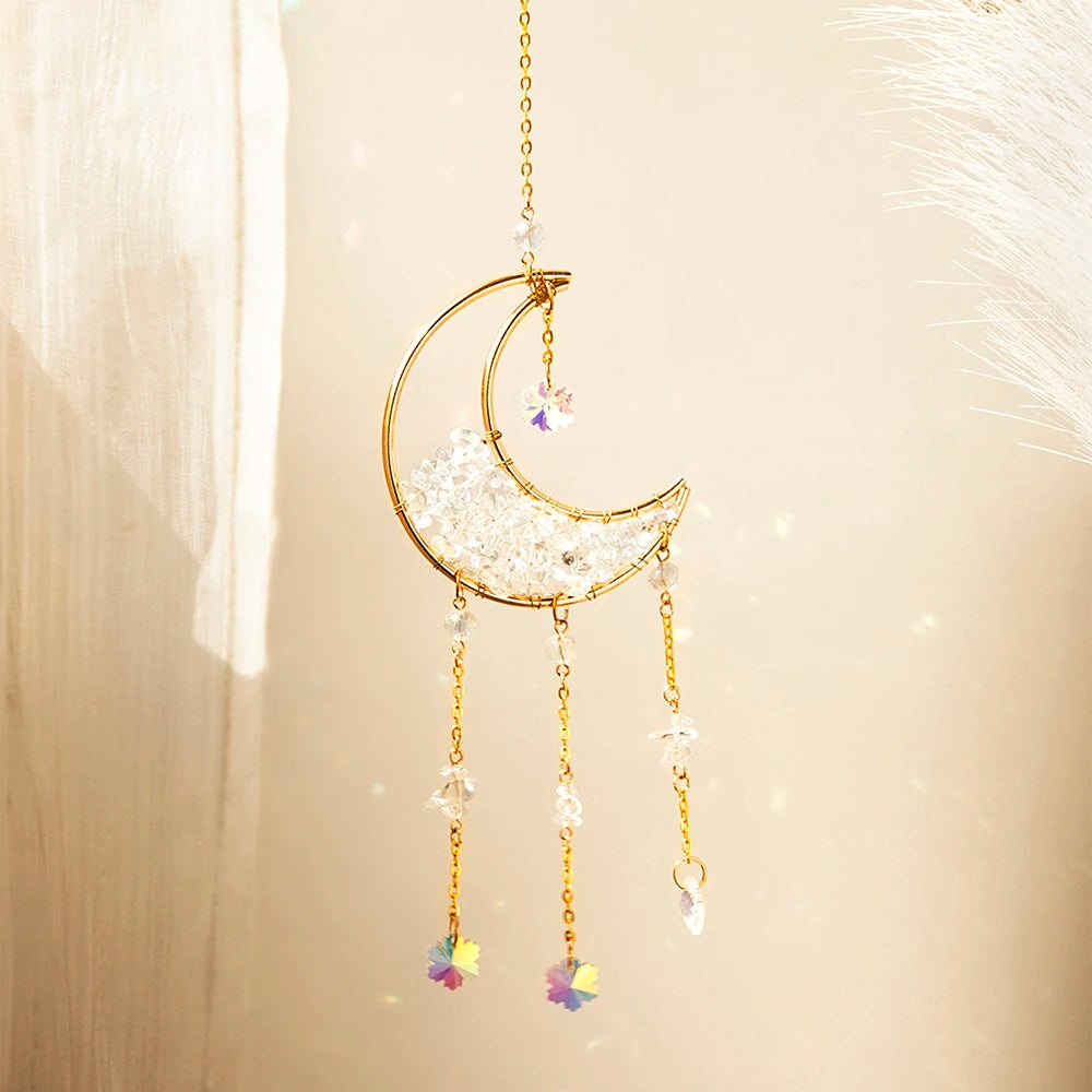 A golden crescent moon dreamcatcher with a clear crystal charm and dangling prisms.