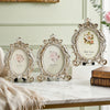 A set of vintage gold oval resin picture frames displayed on a white marble surface.