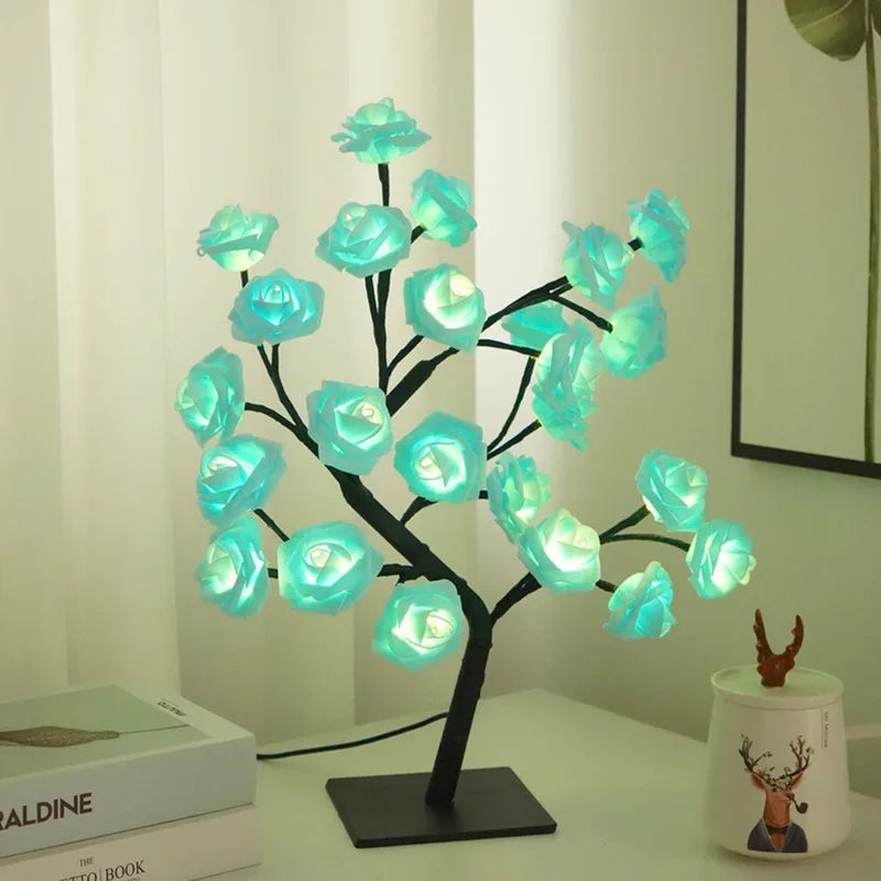 Dunkle Baumskulptur mit leuchtend blauen Rosenblüten, als Nachtlicht-Dekoration.
